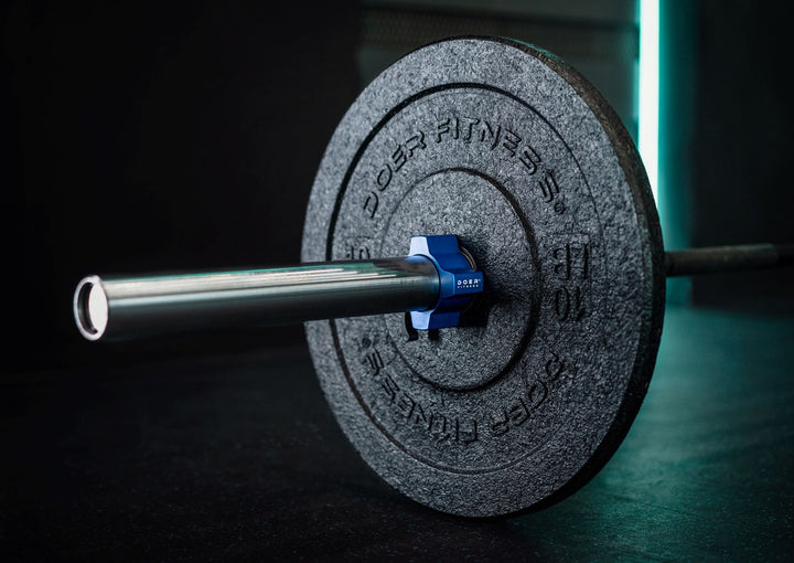 Close-up of a Doer Fitness 10 LB black bumper plate on an Olympic barbell with a blue aluminum collar.