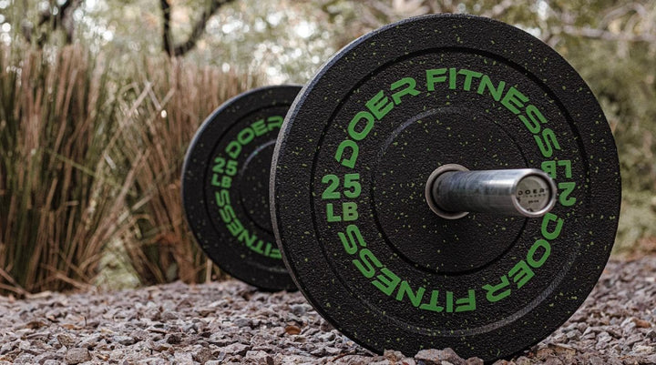 air of Doer Fitness 25 LB green fleck bumper plates on an Olympic barbell for outdoor training.